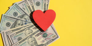 Red heart sitting on top of a money